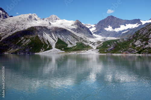 Glaciers and mountains reflecting in calm ocean water in Glacier Bay, Alaska