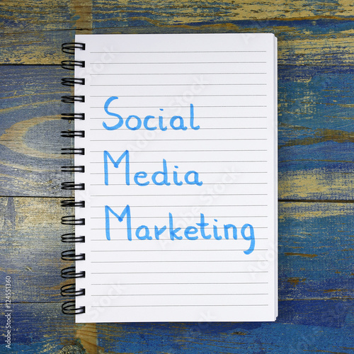 Social Media Marketing text written in notebook on wooden background photo