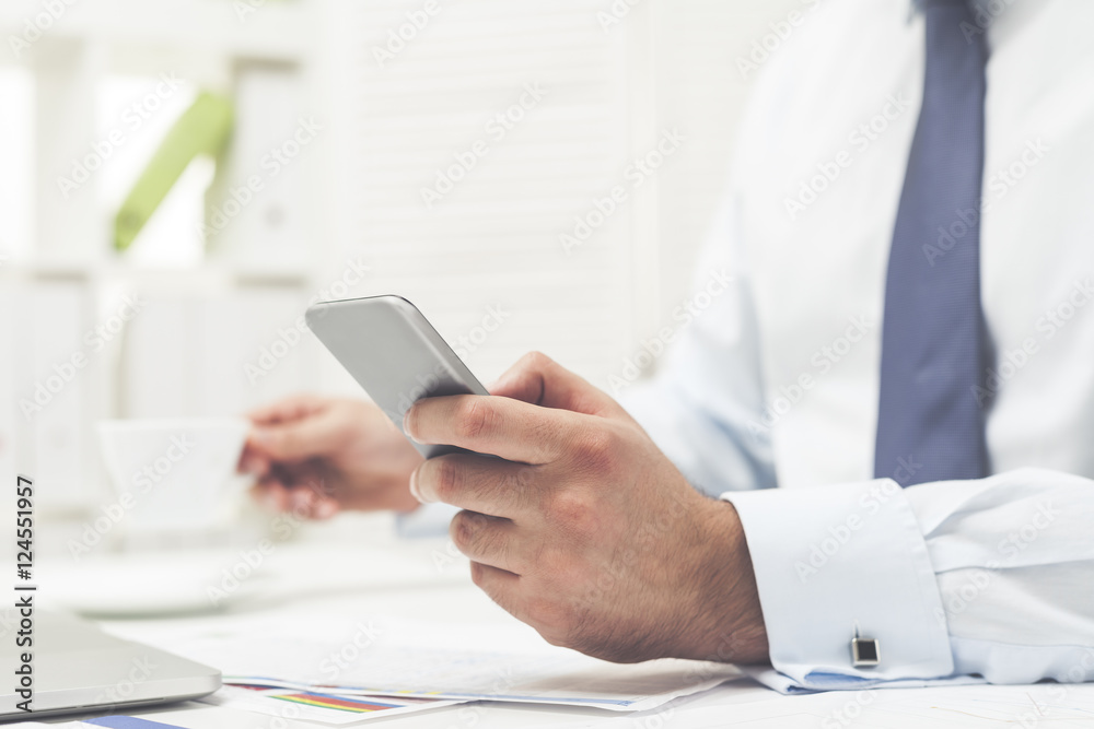 Man in gray tie with his cell phone and coffee Man in gray tie with his cell phone and coffee