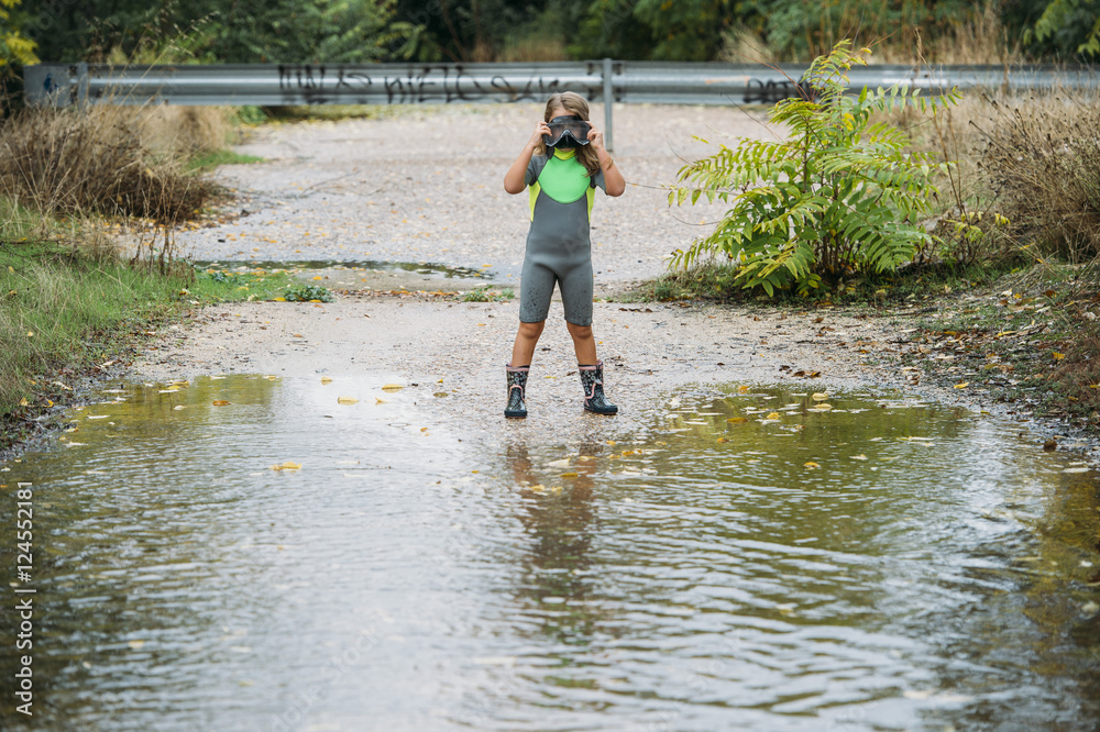 beautiful girl playing in the puddle of water with neoprene beautiful girl playing in the puddle of water with neoprene