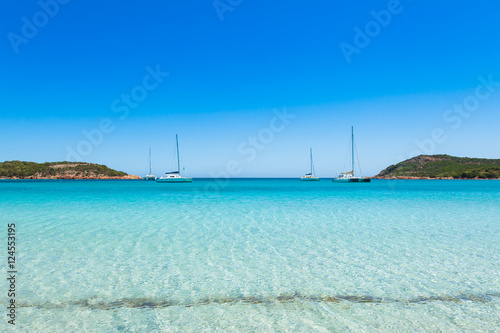 Boats mooring in the turquoise water of  Rondinara beach in Cors