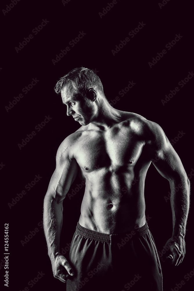 Muscular, strong and sexy man isolated on black background