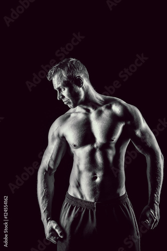 Muscular, strong and sexy man isolated on black background