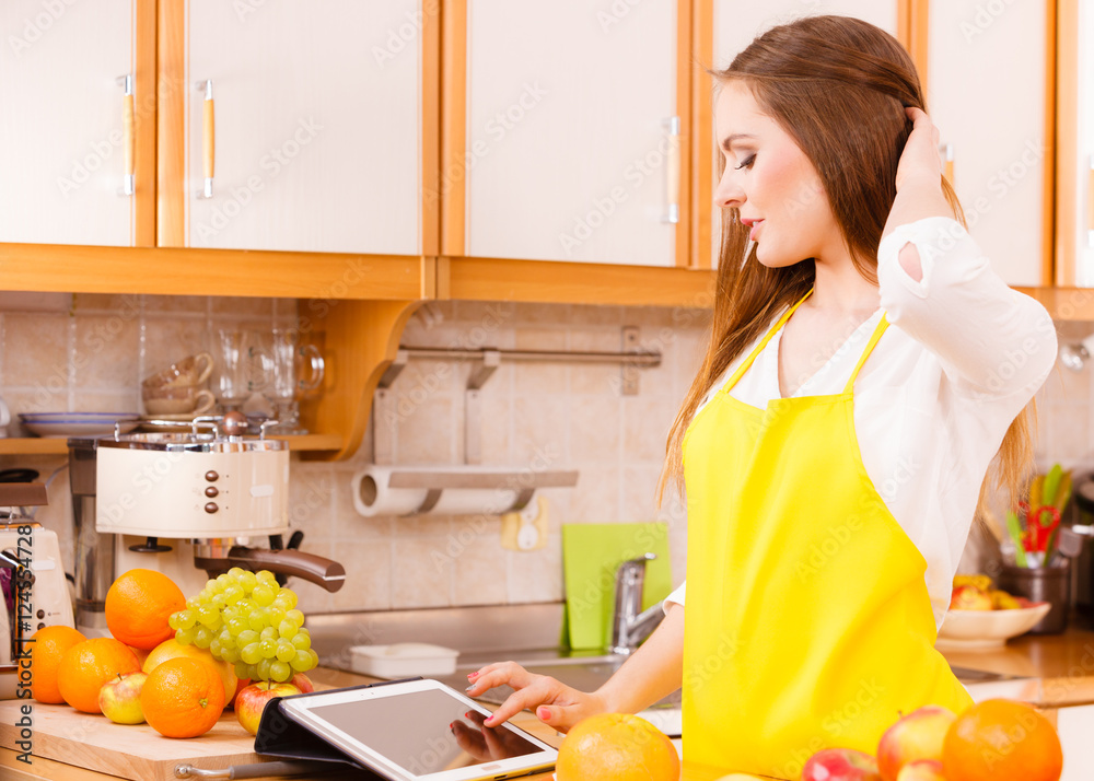 Woman housewife in kitchen using tablet Woman housewife in kitchen using tablet