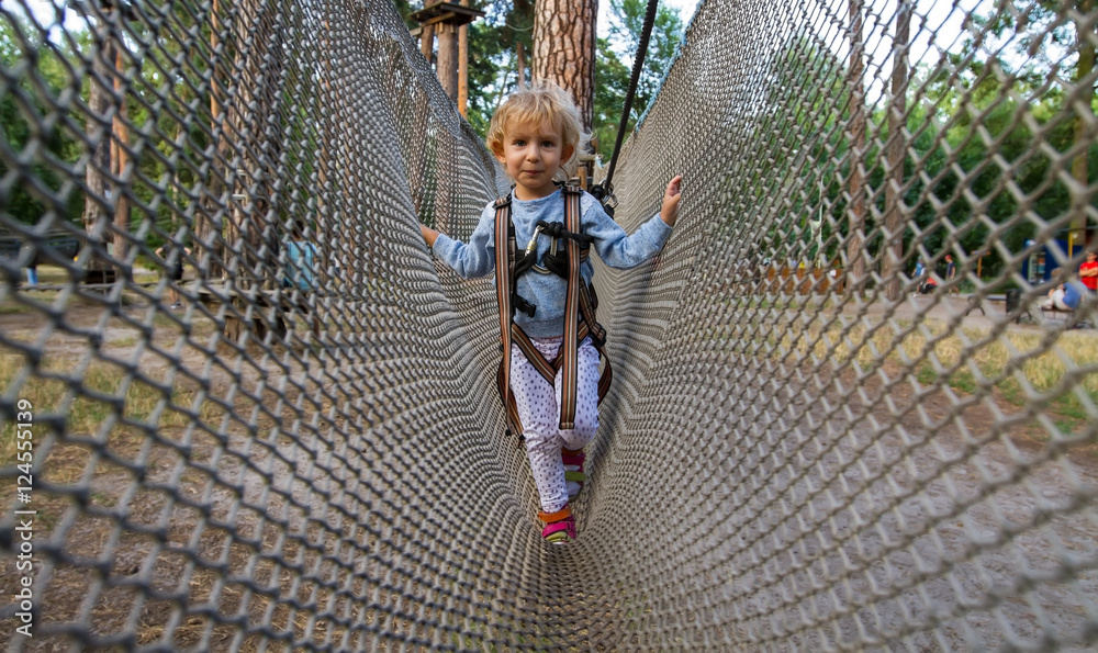 Little girl overcomes obstacles. / Three-year girl the blonde with a ...