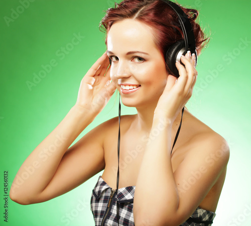 Young happy woman listening to music with headhones photo