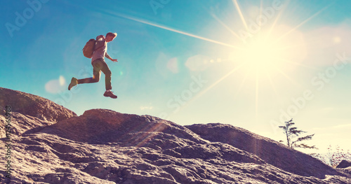 Man jumping over gap on mountain hike