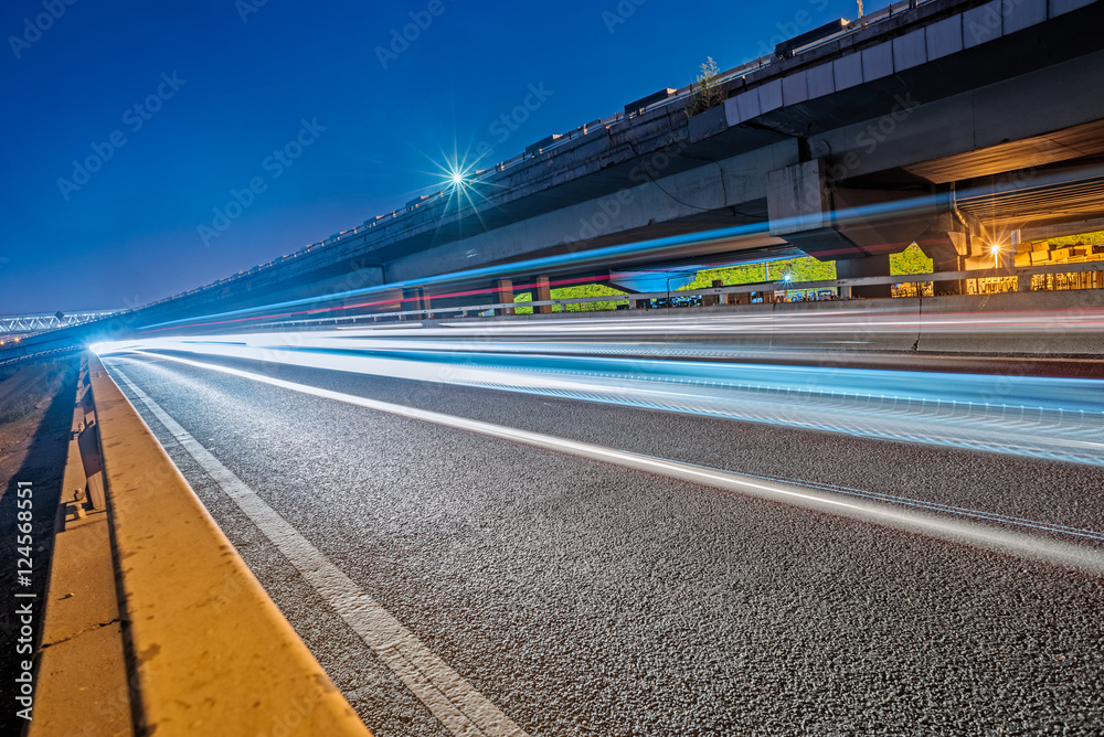 blurred traffic light trails on road at night in China.