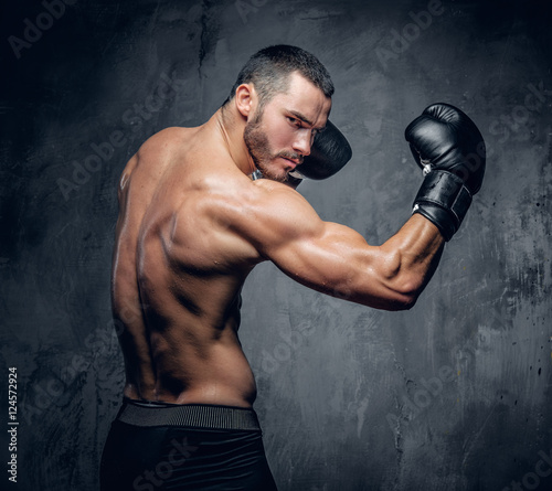Aggressive shirtless boxer on grey background. © Fxquadro