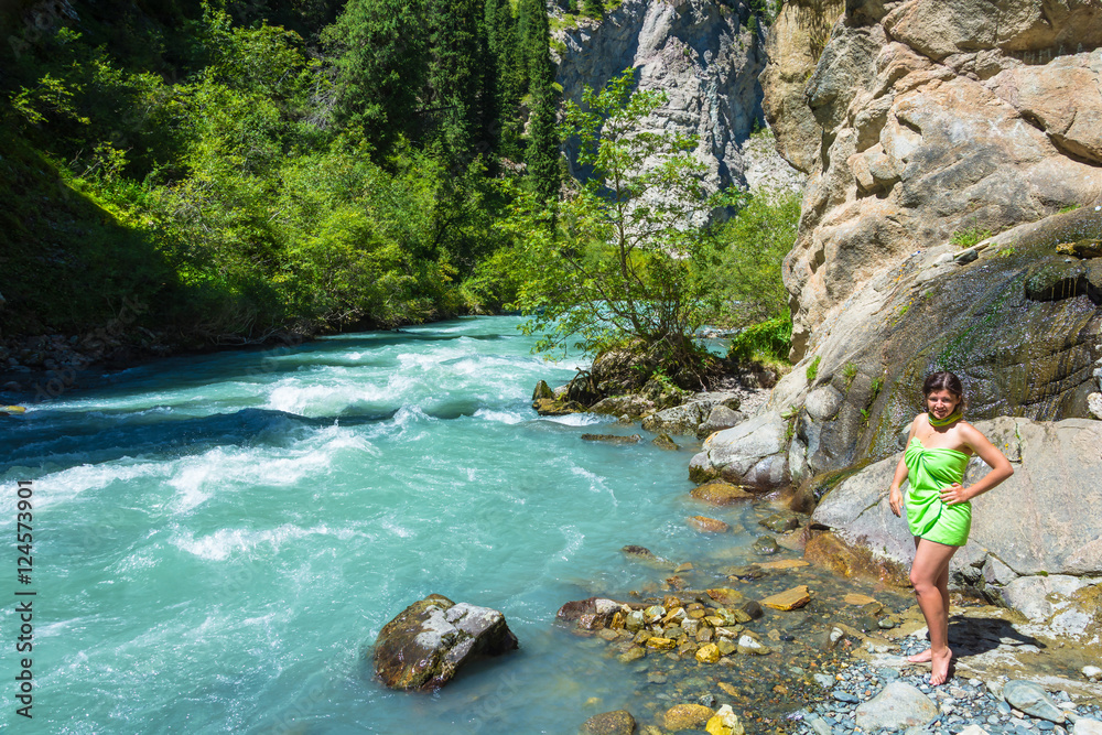 A beautiful girl on the bank of a mountain stream, Kyrgyzstan. A beautiful girl on the bank of a mountain stream, Kyrgyzstan.