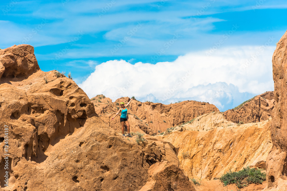 The beautiful girl in orange rocks of the canyon Tale, Kyrgyzsta