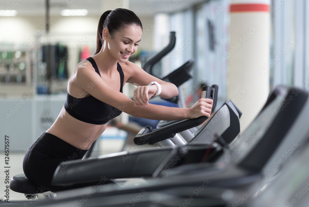 Active girl running on a treadmill and wearing smart watch Active girl running on a treadmill and wearing smart watch