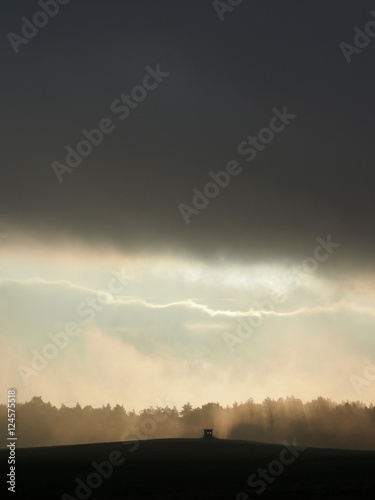 Dunkle Wolkenwand über kleiner Hütte auf dem Feld