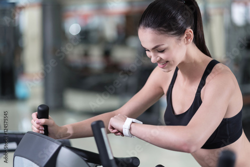 Active woman looking at smart watch in a gym
