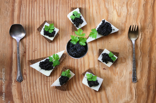 snack black caviar on a wooden background