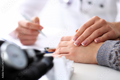Friendly female doctor hold patient hand in office