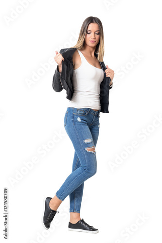 Young casual girl with ombre hairstyle taking off leather jacket. Full body length portrait isolated over studio white background.