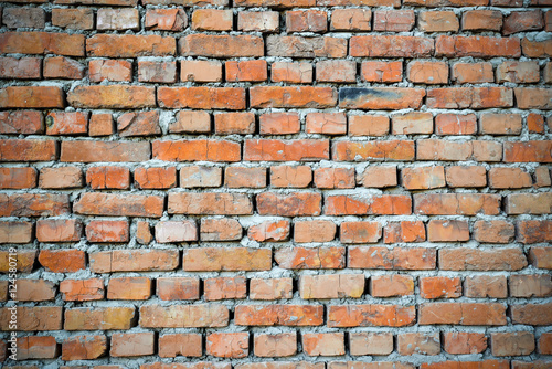 Red brick wall backgraund with darkened edges. Background of old vintage brick wall. Red brick wall texture grunge background perfect for design purposes.