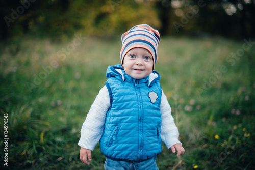 little boy in blue in the autumn park photo