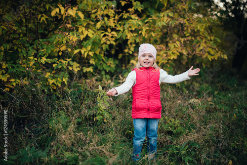little girl in the red in the autumn forest, park