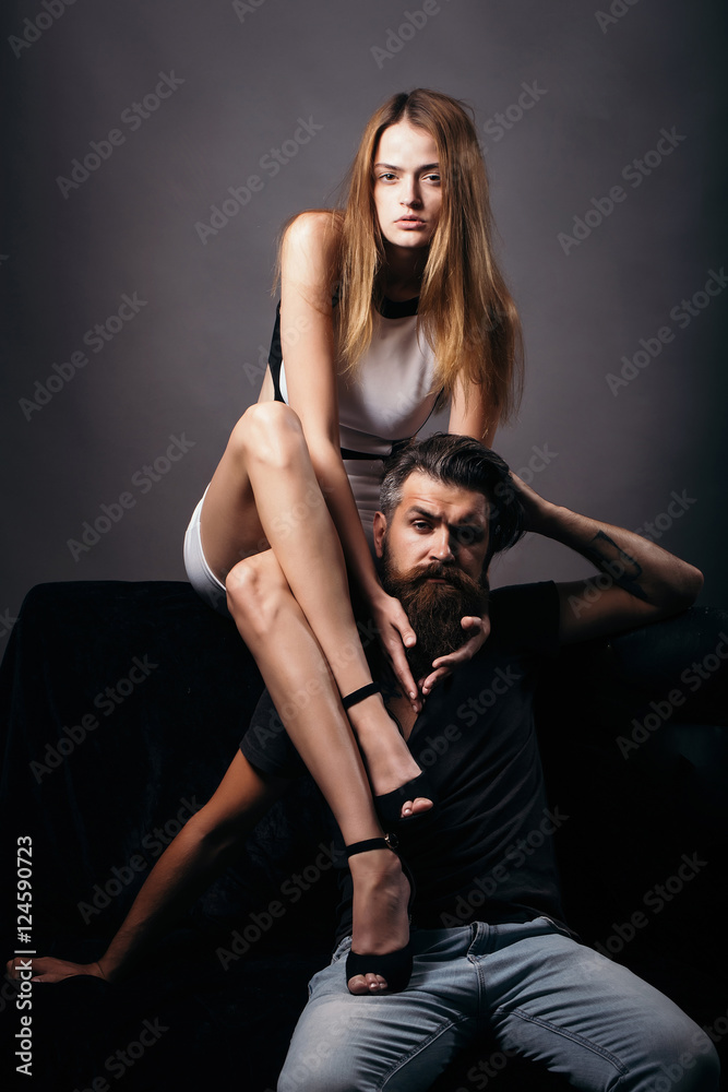 Pretty girl sits on bearded man