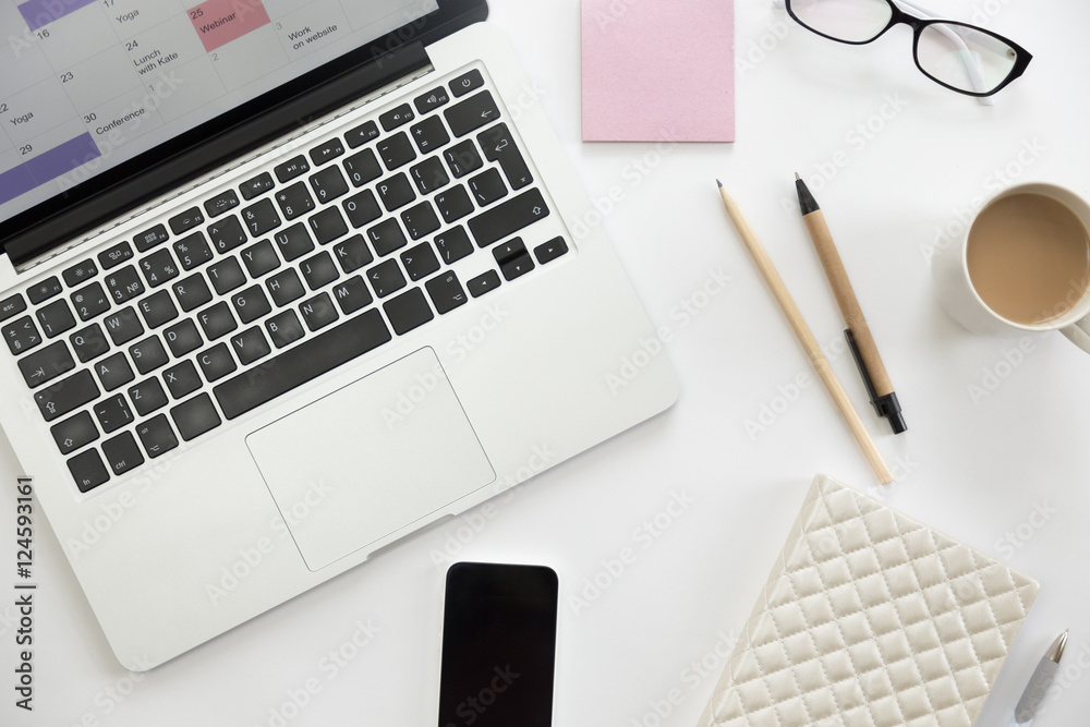 White office desk with glasses, pen, mug, pencil, white notebook and on it. Lady office supply. Business concept, lay flat White office desk with glasses, pen, mug, pencil, white notebook and on it. Lady office supply. Business concept, lay flat
