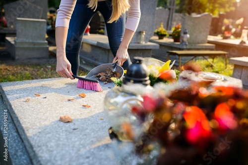 Obraz na płótnie Woman cleans a grave.