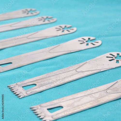 Used saw blades are on green surgery cloth.