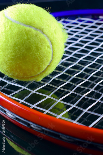 Closeup of  tennis racket with a tennis ball on black background.  © JRJfin