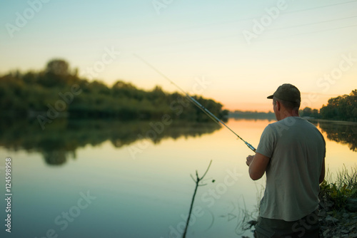 fisher man is fishing on the fishing rod in summer