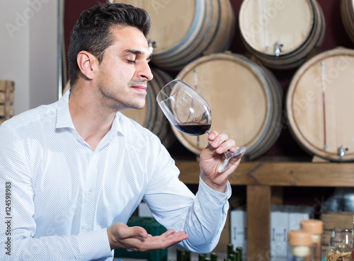 man tasting wine in cellar