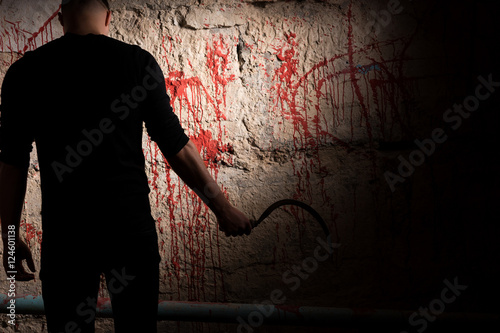 Shadowy figure near blood stained wall