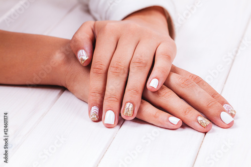 Beautiful manicure of gel varnish. Golden White. Fashion  style  care