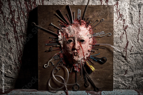 Frightful skinned bloody face of a person stretched open on a wo