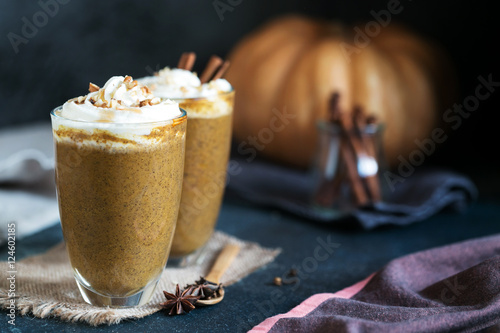 Two glass cups of pumpkin latte topped with whipped cream walnut