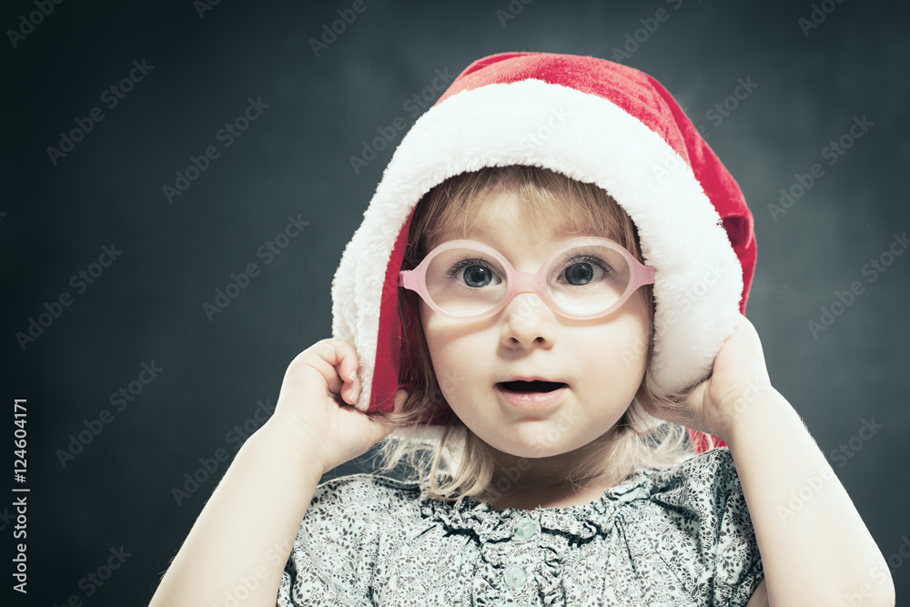 Christmas Child. Cute Little Gir in Santa Hat.