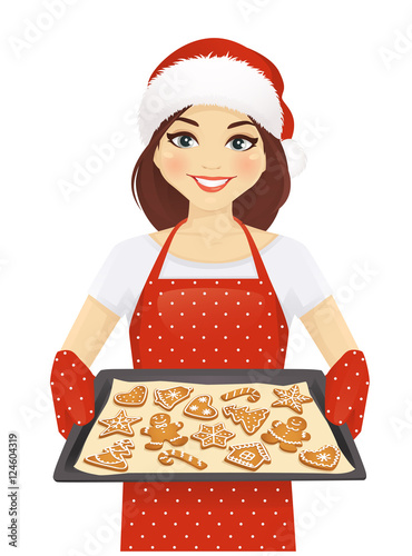 Smiling woman holding baking tray with christmas cookies wearing santa hat isolated