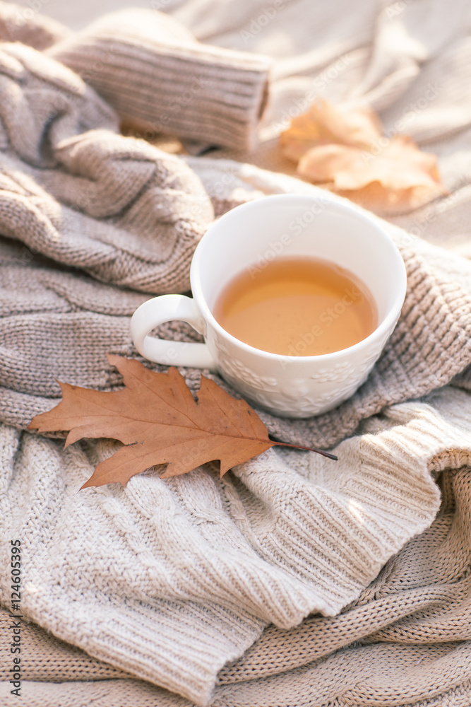 Warm knitted sweater,cup of hot tea and red thermos Warm knitted sweater,cup of hot tea and red thermos