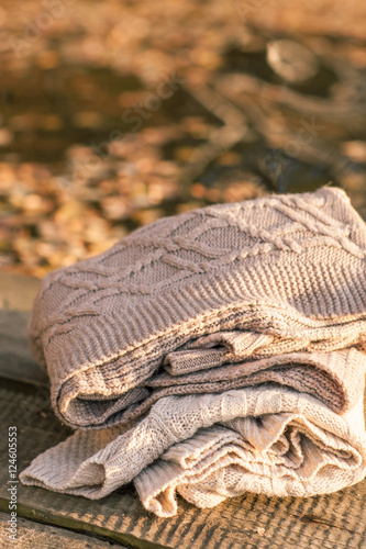 Pile of knitted winter clothes on wooden background, sweaters, k