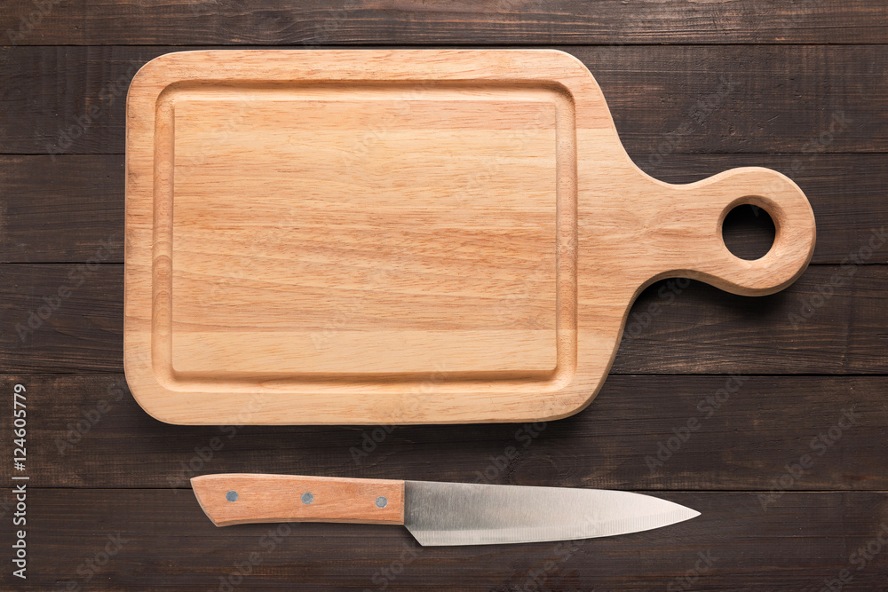 Knife and cutting board on the wooden background. Copy space for your text.