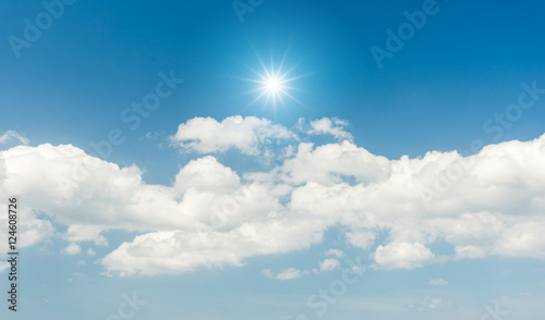 Blue sky with clouds and sun reflection