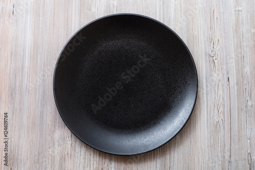 top view of black plate on gray brown table