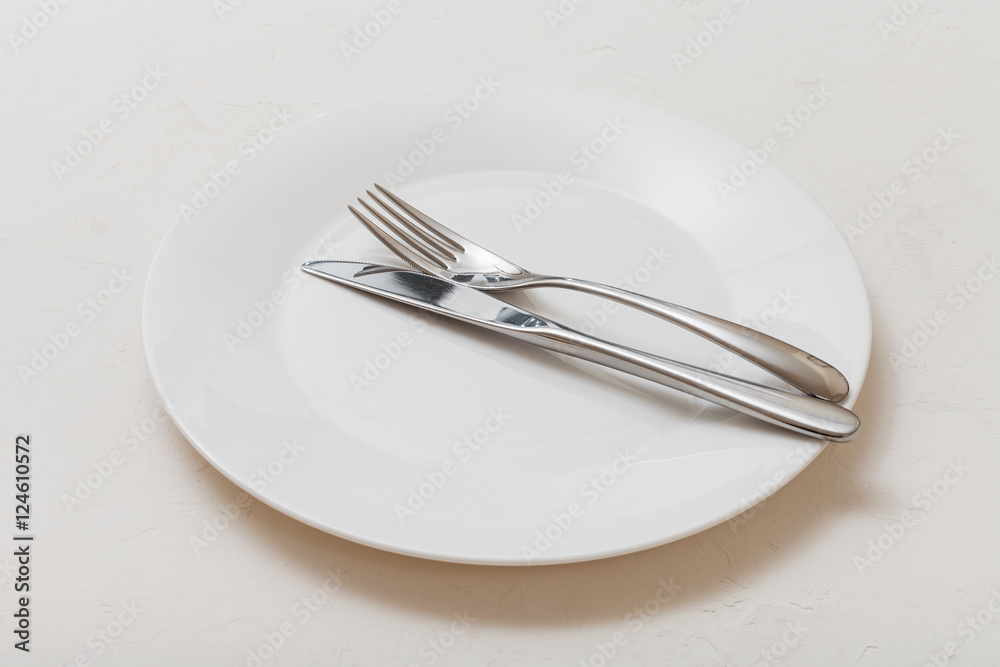 white plate with parallel knife, spoon on white white plate with parallel knife, spoon on white
