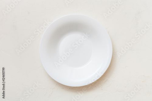 above view of white deep plate on plaster