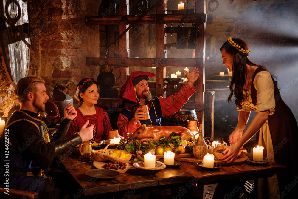 Medieval people eat and drink in ancient castle kitchen interior