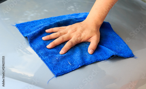 waterless car wash. Men's hand with blue cloth cleaning car phot