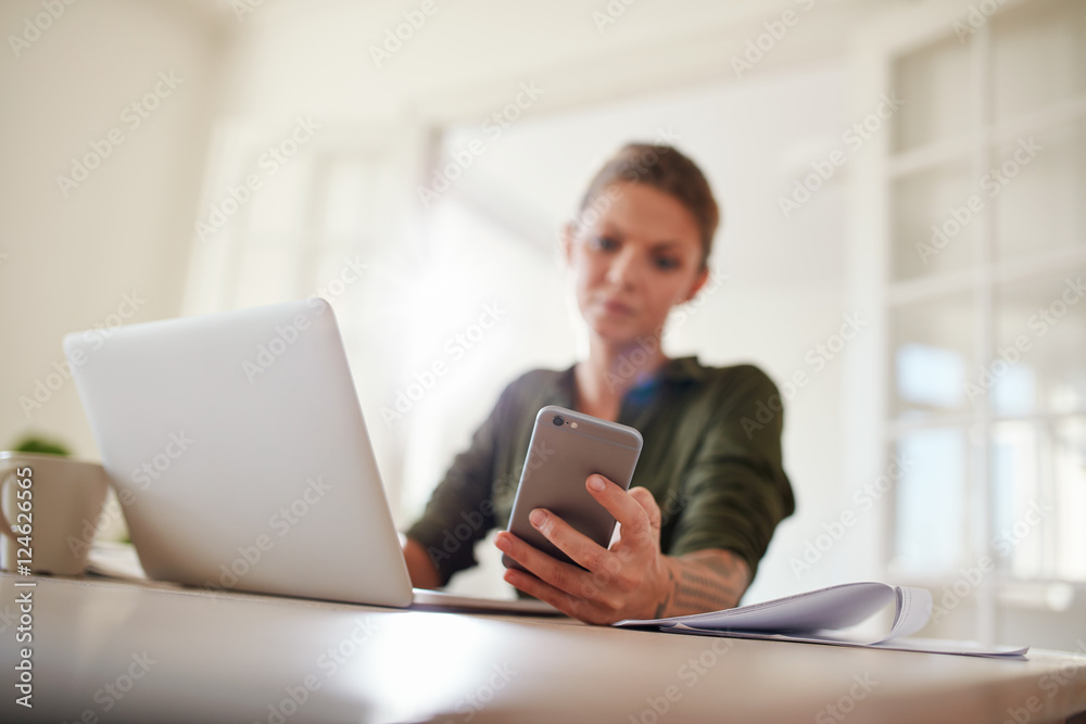 Young woman reading text message on her smart phone Young woman reading text message on her smart phone
