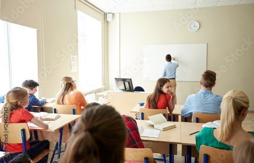 students and teacher writing on school white board