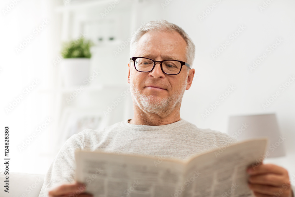 senior man in glasses reading newspaper at home senior man in glasses reading newspaper at home