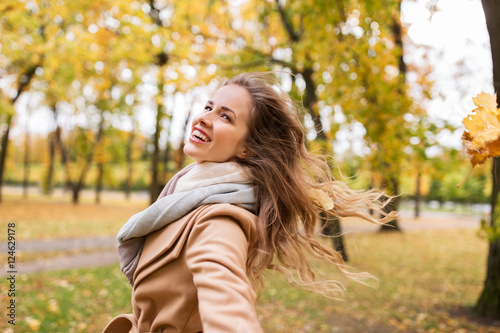beautiful happy young woman walking in autumn park